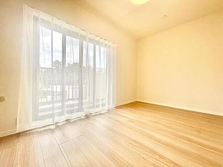 明るい光が差し込む洋室で広々とした開放感が感じられます。ナチュラルなフローリングが空間をすっきりと演出。大きな窓から外の景色も楽しめます。シンプルなデザインでさまざまなスタイルに合わせやすい洋室です。