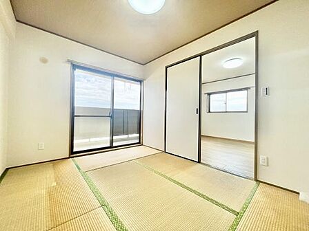 広々とした和室が特徴的で落ち着いた雰囲気を感じられます。大きな窓から自然光が入り明るい印象です。スライド式の扉で空間の使い方にも柔軟性があります。畳の目が美しく揃えられています。