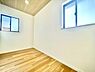 子供部屋：2面採光の子供部屋は明るさが感じられる空間です。白を基調にした壁と木目調の床が清潔感の印象を与えます。天井のアクセントやシンプルな内装が特徴です。開放感のあるレイアウトが魅力となっています。