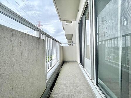 開放感のあるバルコニーはガラス手すりで視界も広がります。床面にはモダンなデザインが施されています。天候に左右されにくい屋根付きで使いやすさが特徴です。清潔感のあるスペースでお手入れも簡単です。
