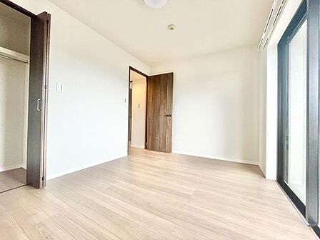 明るい光が差し込む洋室です。ナチュラルなフローリングが室内を落ち着いた雰囲気に演出します。大きな窓が開放感を与え快適な空間を実現しています。シンプルな内装でアレンジもしやすい洋室です。