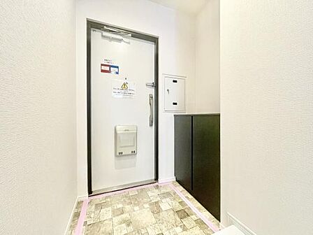 白を基調とした明るい玄関は空間がすっきりとした印象です。便利な収納スペースが設けられており使い勝手も配慮されています。タイル調の床が落ち着いた雰囲気を演出しています。