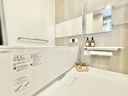 洗練されたデザインが印象的なバスルームです。広々とした浴槽が特徴です。鏡や収納スペースもバランスよく配置されています。小物やバスグッズの置き場も確保されています。清潔感のある空間です。