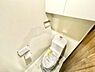 トイレ：清潔感のあるトイレです。収納スペースが上部に設けられており小物の整理に便利です。ペーパーホルダーと手洗い一体型のデザインが特徴的です。明るい色調で空間が広く感じられます。