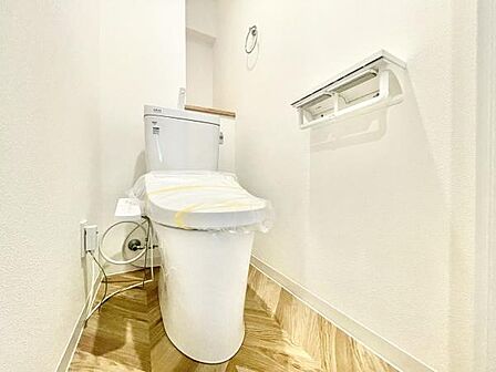 明るく清潔感のあるトイレ空間です。壁も床もシンプルな色合いで手入れがしやすい印象です。ペーパーホルダーの設置位置も使いやすくすっきりとした配置になっています。直線的なデザインが特徴的です。