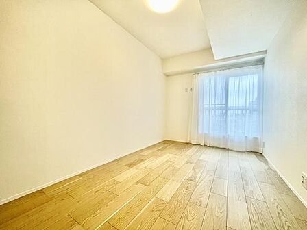 明るい光が差し込む洋室です。ナチュラルなフローリングが落ち着いた空間を演出しています。シンプルな内装でインテリアのアレンジがしやすいです。窓からの眺めも楽しめます。清潔感ある洋室となっています。