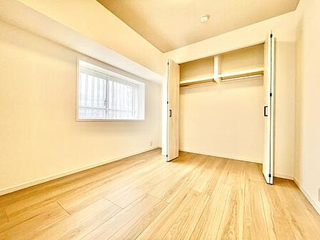 明るい窓から自然光が差し込む寝室です。広々としたクローゼットで収納も便利です。シンプルな内装が様々なインテリアに対応します。落ち着いた空間づくりができます。清潔感のあるフローリングも魅力的です。