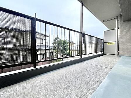 開放感のあるバルコニーはゆとりある広さが魅力です。金属フェンスで視界が確保されています。床は滑りにくい仕上げとなっています。屋根付きで雨の日も安心して利用できます。