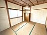 和室：窓から明るい光が差し込む和室です。畳の香りが感じられる落ち着いた室内になっています。天井や柱の木目が和の風合いを演出しています。