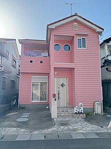 外観：ピンク色の外観が特徴的な建物です。丸い窓と正面のデザインが印象的で個性を演出しています。広々とした玄関まわりも視線を集めます。明るい雰囲気の外観が目を引きます。