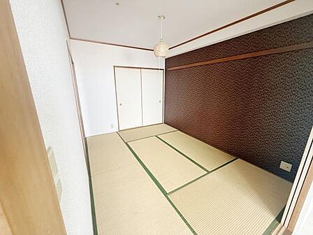 落ち着いた雰囲気の和室です。アクセントとなる壁面が印象的で空間に個性があります。収納スペースとして便利な押し入れも備わっています。畳の清潔感が感じられます。和の趣を楽しめるお部屋です。