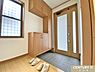 玄関：高さのある収納は家族の人数分の靴もたっぷりと収納できます。すっきりと片付いた玄関では家族が並んで靴を履き、出かけることができます。