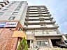 外観：複数階建てのマンション外観、周辺に商業施設あり