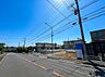 外観：青空の下、広い道路沿いの住宅街の様子です