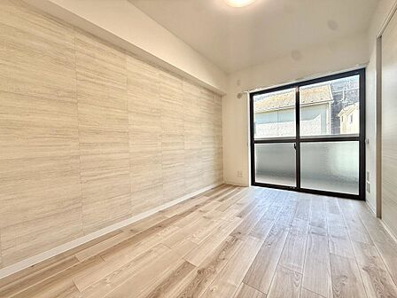 窓から光が入る明るい洋室の室内