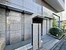 外観：タイル張りのマンション外観とエントランス前の歩道