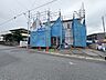 外観：建築中の建物を覆う青い防護ネット