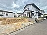 外観：住宅街の一角にある空地と隣接する住宅の外観