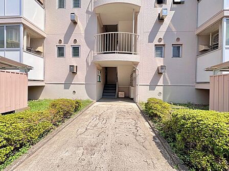 マンションのエントランスと通路、植栽が整備された外観