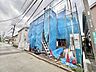 外観：青い養生シートで覆われた建物の外観
