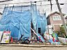 外観：青い養生シートで覆われた建築中の建物