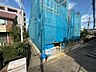 外観：青い養生シートで覆われた建築中の建物