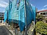 外観：青いネットで覆われた建築中の建物