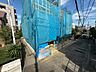 外観：青いシートで覆われた建物と前面道路