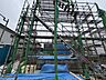 外観：建築中の建物を覆う足場と養生シート