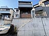 外観：コンクリート擁壁の上に建つ住宅の外観