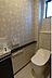 トイレ：窓が設置されており明るさと換気に配慮されたトイレです。壁紙のデザインが空間にやわらかな印象を与えています。使いやすい位置にペーパーホルダーや棚が設置されています。清潔感を感じる内装です。