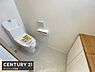トイレ：清潔感のあるシンプルなトイレ空間です。壁付けタイプのペーパーホルダーがすっきりとした印象を与えます。収納スペースも備わっており使い勝手の良さが感じられます。床は明るい色合いでお手入れも簡単そうです。