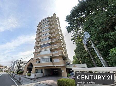 シンプルな外観デザインが特徴のマンションです。周囲には豊かな緑が広がっています。道路に面しており開放感があります。しっかりとした建物構造が感じられます。