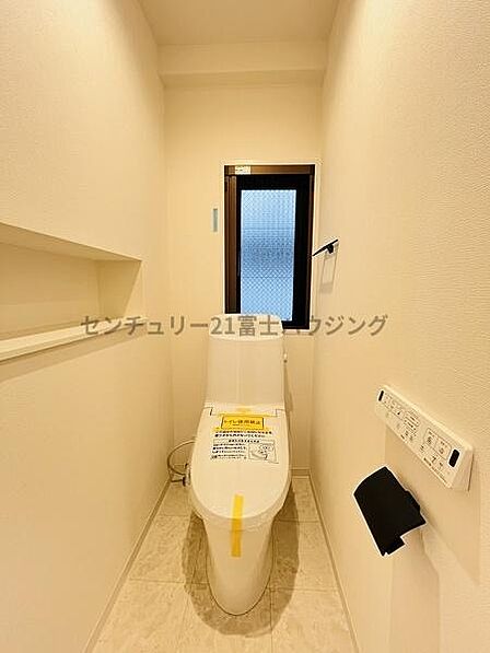 清潔感ある明るい内装に、ペーパーホルダーなどの黒いアイアン調パーツがモダンなアクセント。ディスプレイスペースとしても使える壁面ニッチ棚も便利です。