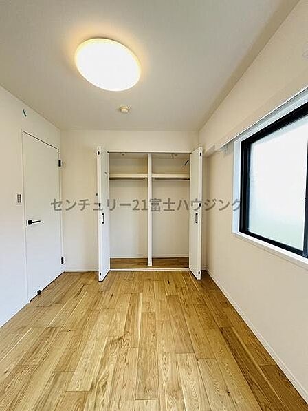 心地よい光が差し込む、ナチュラルモダンな洋室。温もりある木目調の床に黒のサッシが映える、シンプルで美しい空間です。