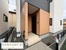 玄関：シンプルで落ち着いたデザインの玄関が特徴です。屋根付きのアプローチで天候を気にせず出入りできます。モダンな外壁が建物全体の印象を引き締めています。少し高くなった玄関ポーチがアクセントになっています。