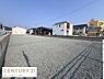 外観：広々とした現地土地写真です。周囲には住宅や店舗が並び見晴らしの良さが感じられます。整地済みの状態で敷地の使いやすさが伝わります。道路に面しておりアクセスもスムーズです。