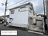 その他：白を基調とした外観が特徴の住宅です。角地に面しており車庫スペース付きとなっています。窓にはシャッターが設置されています。住宅街の一角にある一戸建てです。周辺は道路が広めで車の出し入れも便利です。