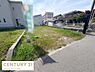 外観：道路に面した現地土地写真です。敷地は平坦で利用しやすそうな形状です。周囲には住宅や建物が立ち並び生活環境が整っています。舗装された道路からのアクセスも便利です。