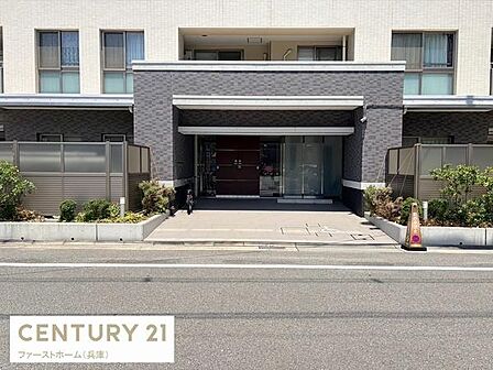 エントランスは落ち着いた色合いで上品な雰囲気です。広々としたアプローチ部分が印象的です。周囲には植栽が施されており整った景観が整っています。建物の正面はスッキリとしていて全体的に清潔感があります。