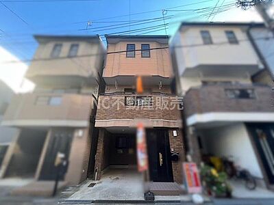 外観：すっきりとしたフォルムの外観が印象的です。ブラウンのタイルが落ち着いた雰囲気を演出しています。ガレージ付きで雨の日も安心できます。周囲の建物と調和したデザインです。都市型住宅の魅力を感じる外観です。