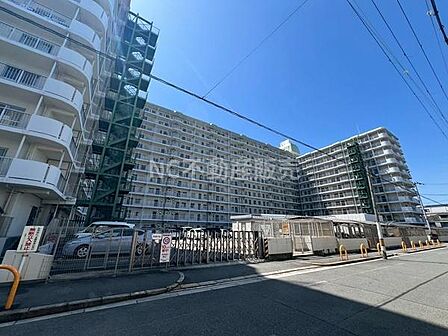 大規模なマンションで外観は整然としています。駐車場が隣接しており利便性が高いです。青空と建物のコントラストが目を引きます。複数階にわたり広がる住戸が特徴的です。