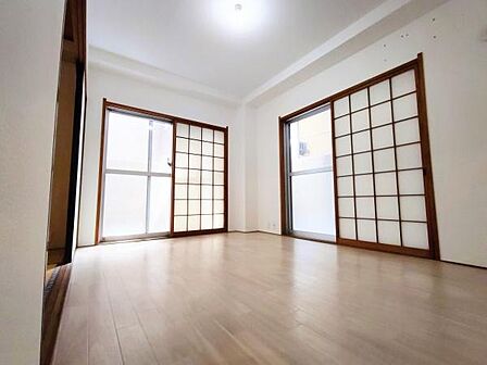 明るい光が差し込むリビングは広々とした空間が広がっています。障子戸が和の雰囲気を演出しており落ち着いた印象です。床材もナチュラルカラーですっきりとしたデザインです。角部屋ならではの二面採光です。