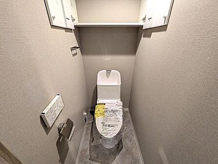 快適にご利用いただける温水洗浄便座を採用し、清潔で心地よいトイレ空間を実現しています。上部に棚もあり収納充実。