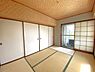 和室：壁面には押し入れ完備。天井には編み込み調の意匠が施され、趣のある雰囲気を演出しています。バルコニーへの動線もスムーズで、採光・通風ともに良好な一室です。
