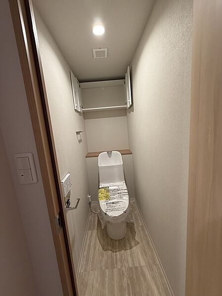 ウォシュレット機能付きのトイレ。収納もあり実用性も兼ね備えた造り。