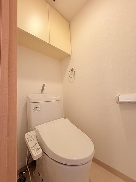 ウォシュレット機能付きのトイレ。収納もあり実用性も兼ね備えた造り。