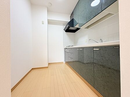 壁付のキッチンは上部に収納が作りやすいのがメリット。空間を有効活用したすっきりとしたデザイン。