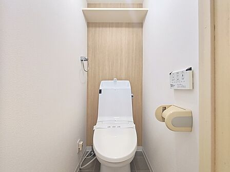 ウォシュレット一体型のシャワートイレ。 上部には収納棚を備え付けました。