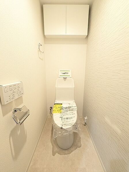 ウォシュレット機能付きのトイレ。収納もあり実用性も兼ね備えた造り。